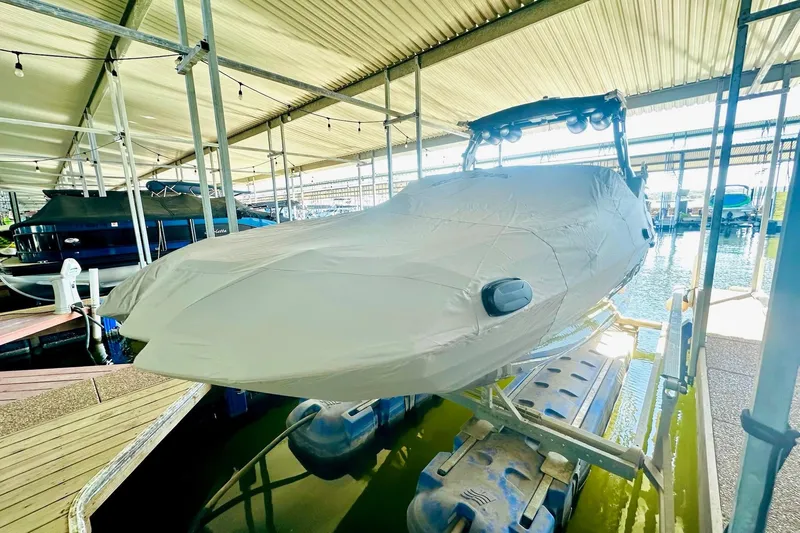 Slide: The Image of 2020 Supra SE550 boat covered in a marina dock, under a metal roof. - 16