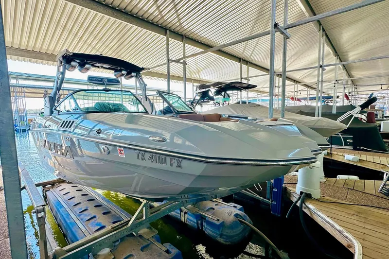 Slide: The Image of 2020 Supra SE550 boat docked in a covered marina, side view. - 18