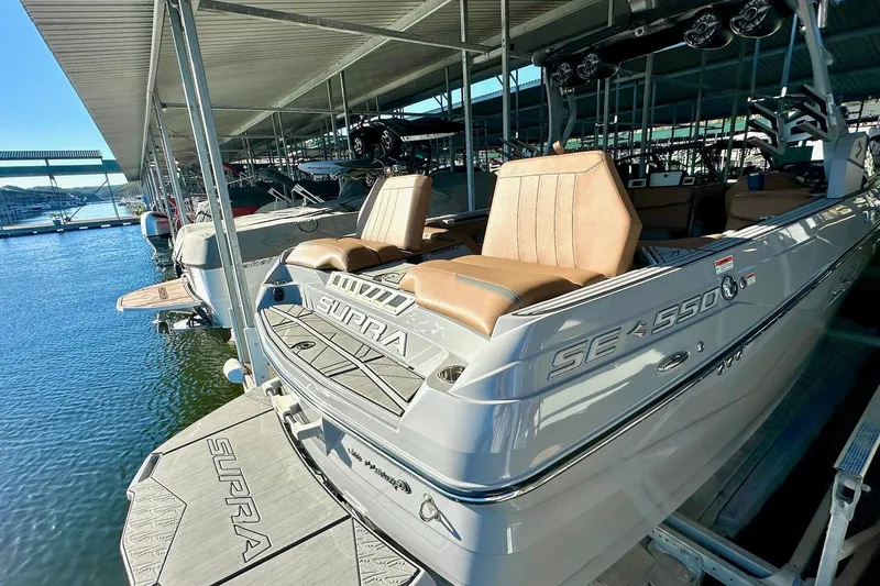 Slide: The Image of 2020 Supra SE550 boat docked, featuring sleek design and comfortable seating. - 19