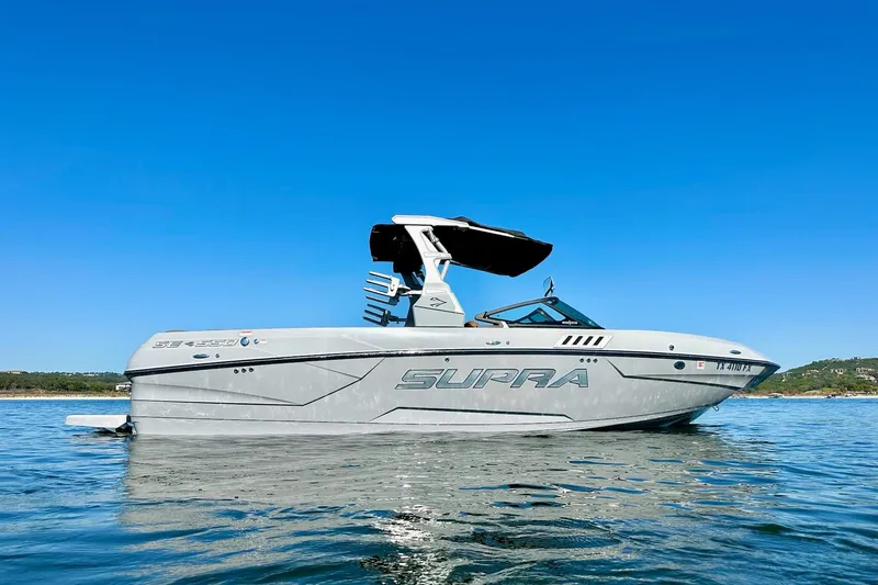 Slide: The Image of 2020 Supra SE550 boat on calm water under clear blue sky. - 3