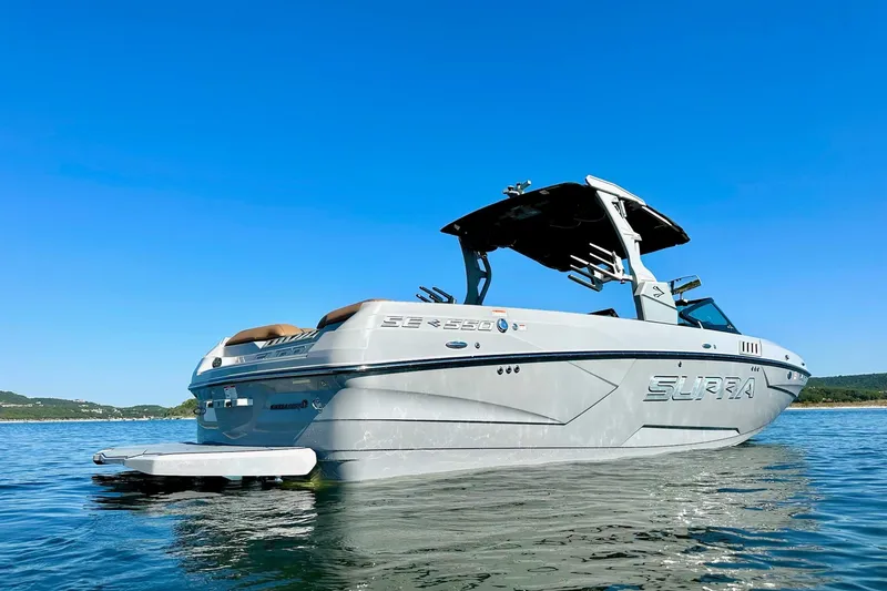 Slide: The Image of 2020 Supra SE550 boat on calm water under clear blue sky. - 4