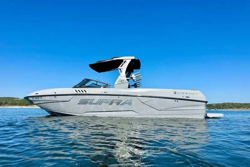Slide: The Image of 2020 Supra SE550 boat on calm water under clear blue sky. - 7