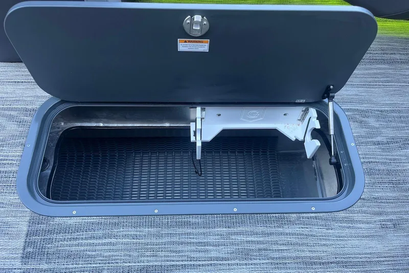 Slide: The Image of Open storage compartment on 2026 Godfrey Monaco 235 SFL boat, featuring secure latch and hydraulic support. - 12