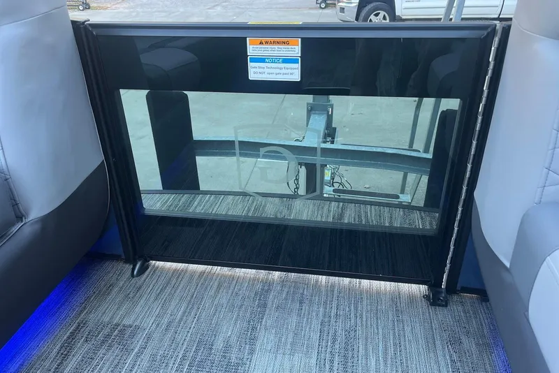 Slide: The Image of Interior view of 2026 Godfrey Monaco 235 SFL boat with safety gate and carpeted flooring. - 32