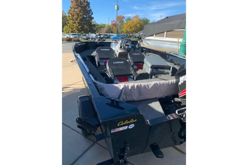 Slide: The Image of 2010 Lowe Fishing Machine 165 boat with seating, parked outdoors on a sunny day. - 4