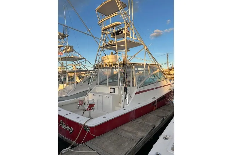 Slide: The Image of 1997 Viking 43 Express boat docked, featuring a red and white exterior with a tower. - 3