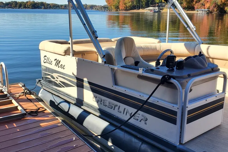 Slide: The Image of 2001 Crestliner LSi 2485 I/O pontoon boat docked on a serene lake. - 4