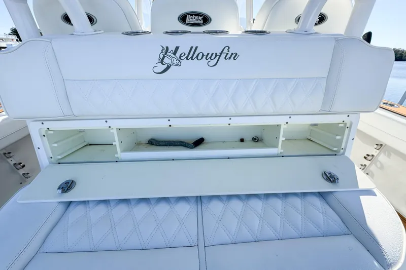 Slide: The Image of 2012 Yellowfin 39 Offshore boat with open storage compartment and white cushioned seating. - 11
