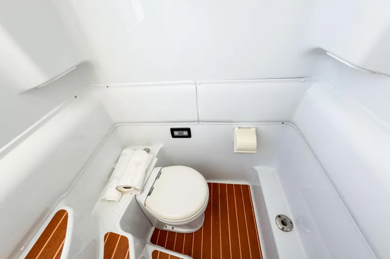 Slide: The Image of 2012 Yellowfin 39 Offshore boat bathroom with wooden flooring and compact toilet. - 16