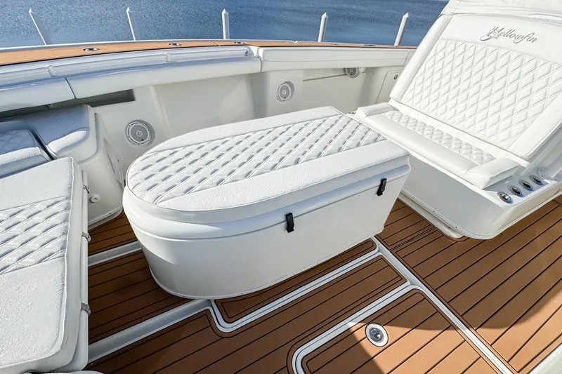 Slide: The Image of 2012 Yellowfin 39 Offshore boat interior with white cushioned seating and teak flooring. - 7