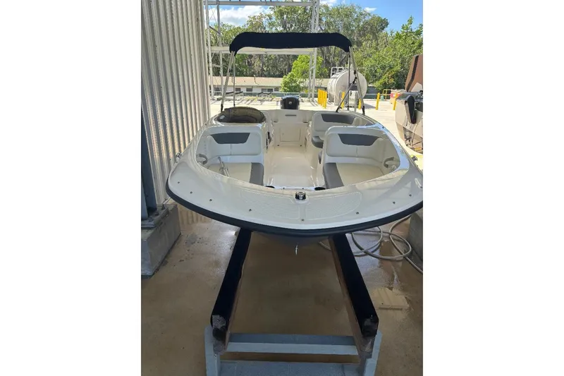 Slide: The Image of 2020 Bayliner Element E18 boat with canopy, docked in a marina setting. - 2