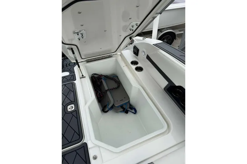 Slide: The Image of Open storage compartment in 2021 Cobalt R6 boat, featuring cup holders and accessories. - 8