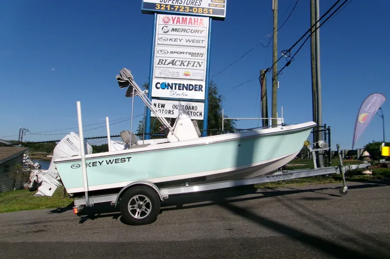 The Image of 2024 Key West 1720 Center Console boat on trailer, displayed outdoors under dealership sign. - 0