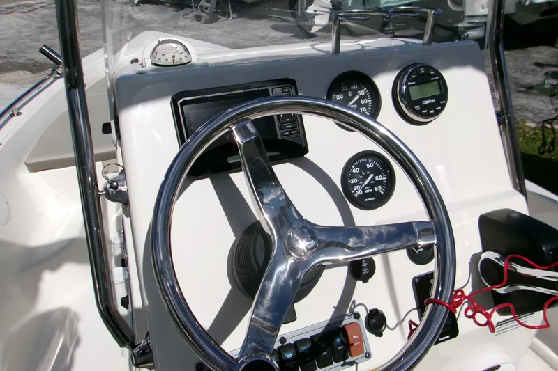 Slide: The Image of 2024 Key West 1720 Center Console boat dashboard with steering wheel and gauges. - 2