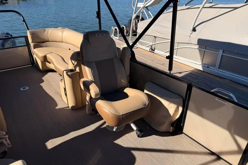 Slide: The Image of 2023 Veranda Relax VR22RC pontoon boat interior with beige seating and lake view. - 11