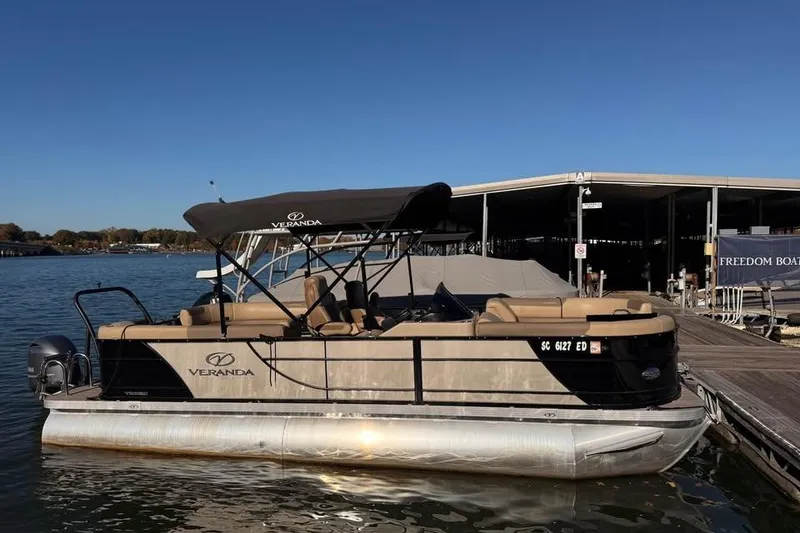 Slide: The Image of 2023 Veranda Relax VR22RC pontoon boat docked on a sunny day. - 2