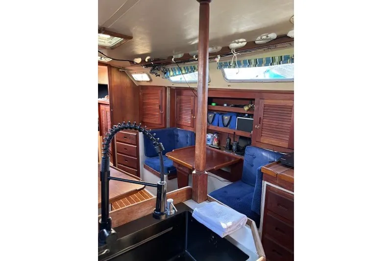 Slide: The Image of Interior of 1986 Catalina 36 MK I sailboat, featuring a compact kitchen and seating area. - 15