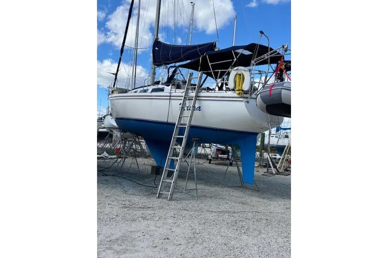 Slide: The Image of 1986 Catalina 36 sailboat docked at a marina under a clear blue sky. - 2