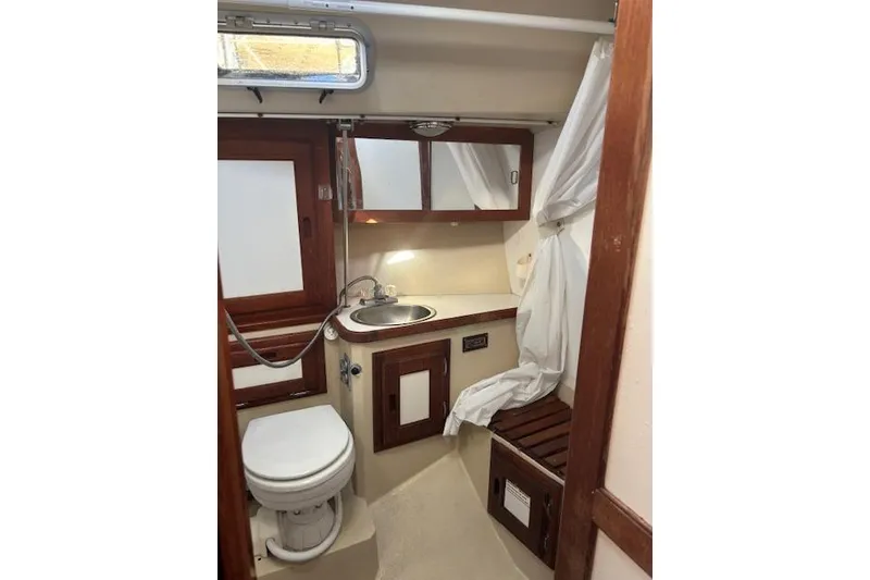 Slide: The Image of Navigation station inside 1986 Catalina 36 MK I sailboat with wooden desk and blue chair. - 21