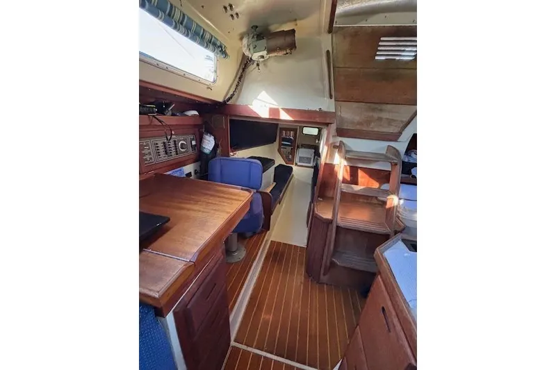 Slide: The Image of Interior of 1986 Catalina 36 MK I sailboat with wooden table and blue seating. - 22