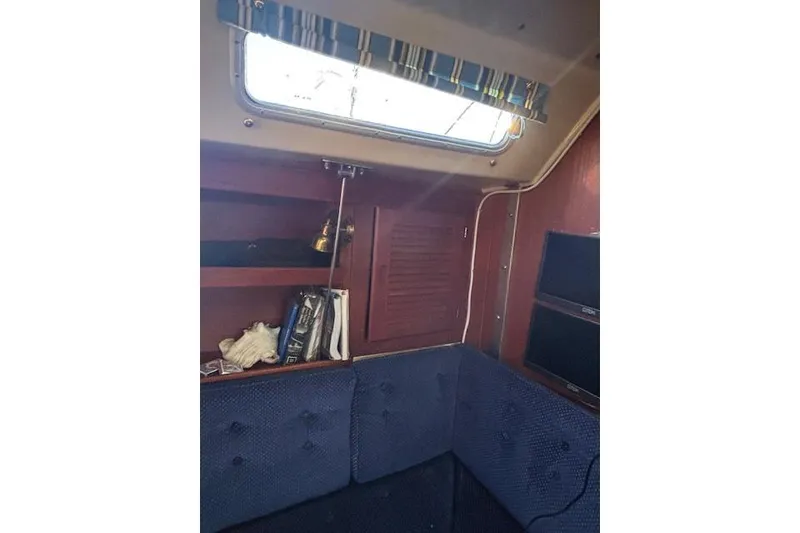 Slide: The Image of Interior of 1986 Catalina 36 MK I sailboat with blue upholstery and wooden shelves. - 36