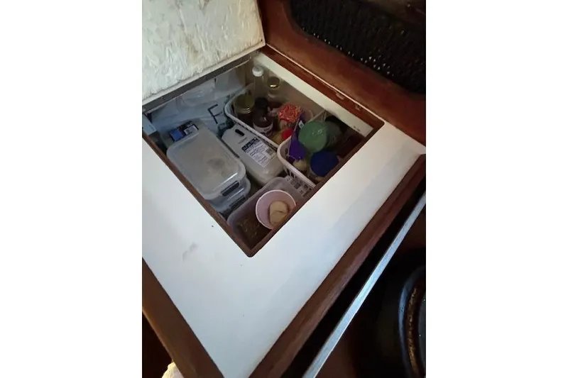 Slide: The Image of Storage compartment in 1986 Catalina 36 sailboat, containing various containers and supplies. - 39