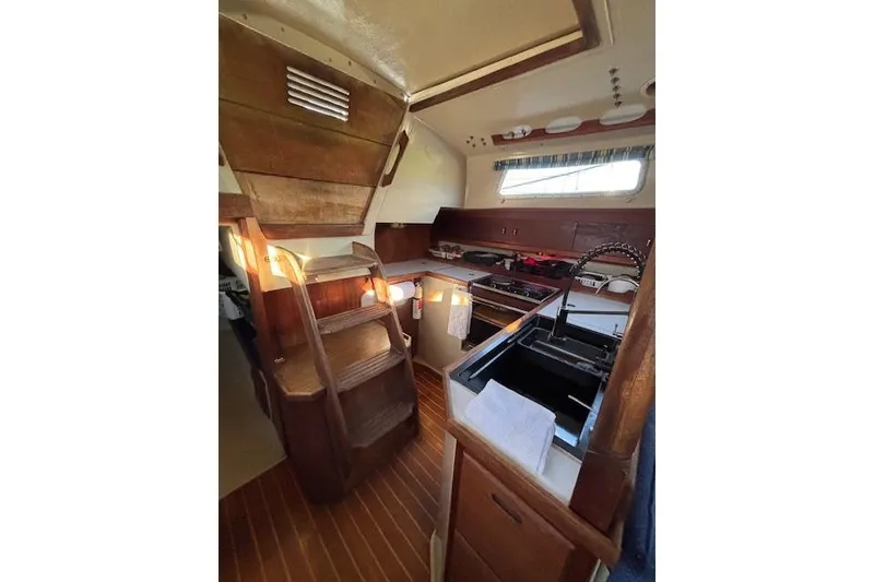 Slide: The Image of 1986 Catalina 36 sailboat docked at marina, with blue sky and calm water. - 5