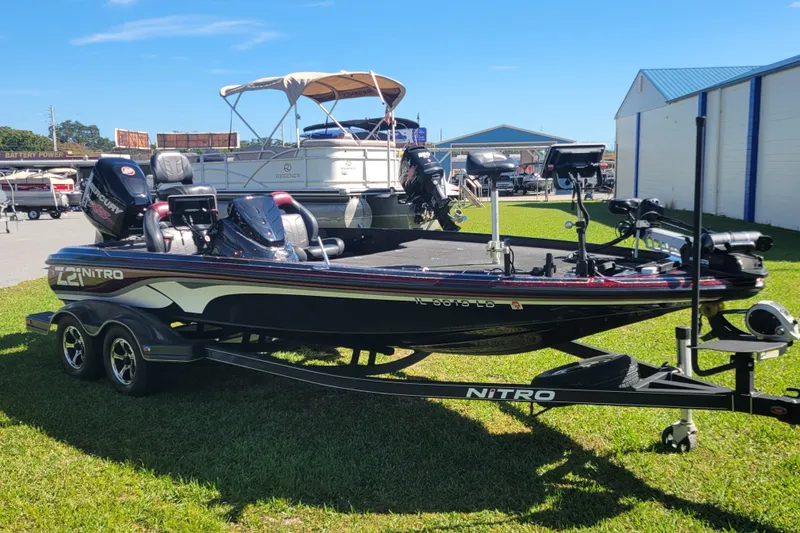 Slide: The Image of 2017 Nitro Z21 Pro bass boat on trailer, parked on grass under clear sky. - 4