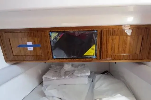 Slide: The Image of 2024 HCB 53 Suenos RXV cabin interior with wooden cabinetry and covered electronics. - 24