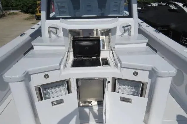 Slide: The Image of 2024 HCB 53 Suenos RXV boat with open storage compartments and sleek design. - 6