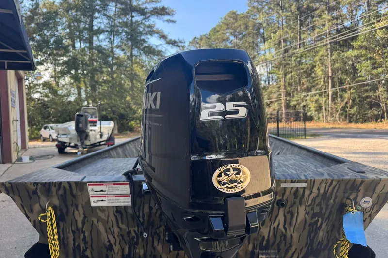 Slide: The Image of 2025 SeaArk 1648 MV Special boat with Suzuki 25 outboard motor, parked outdoors. - 8