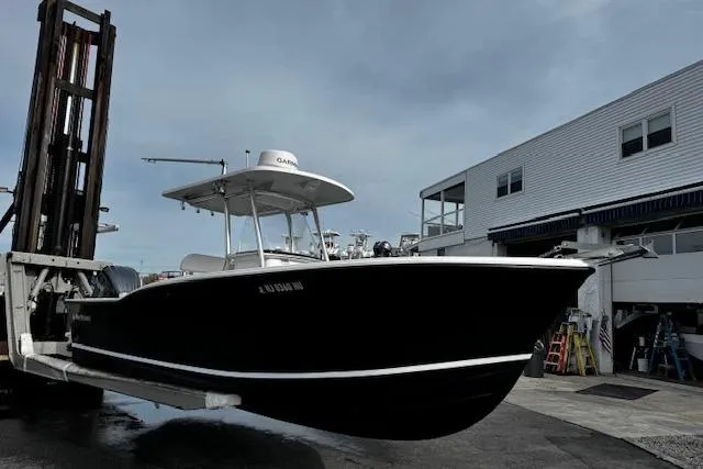 Slide: The Image of 2022 NorthCoast 230 Center Console boat on forklift at marina. - 3