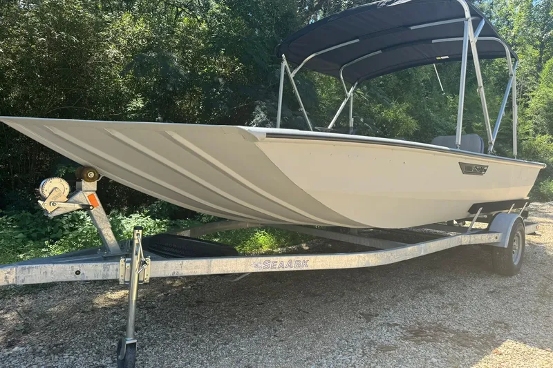 The Image of 2024 SeaArk Shadow 20 boat on trailer, parked outdoors with canopy. - 1