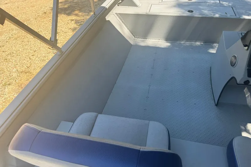 Slide: The Image of 2024 SeaArk Shadow 20 interior with seating and diamond-patterned flooring. - 16