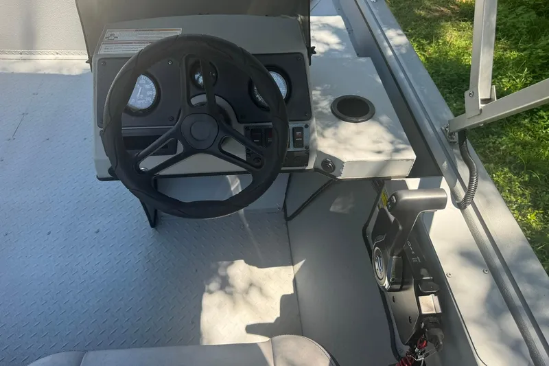 Slide: The Image of 2024 SeaArk Shadow 20 boat cockpit with steering wheel and control panel. - 21