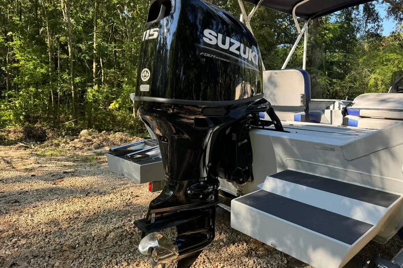 Slide: The Image of 2024 SeaArk Shadow 20 boat with Suzuki 115 outboard motor in a wooded area. - 25