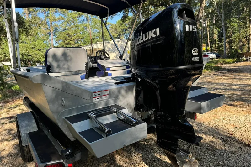 Slide: The Image of 2024 SeaArk Shadow 20 boat with Suzuki 115 outboard motor, parked outdoors. - 26