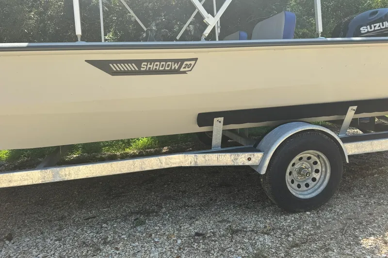 Slide: The Image of 2024 SeaArk Shadow 20 boat on trailer, side view with Suzuki engine visible. - 3