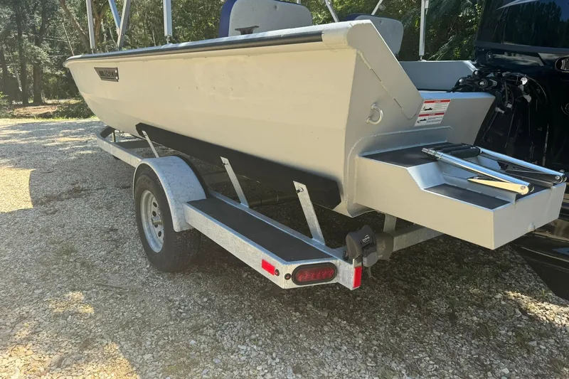 Slide: The Image of 2024 SeaArk Shadow 20 boat on trailer, rear view, parked on gravel. - 4