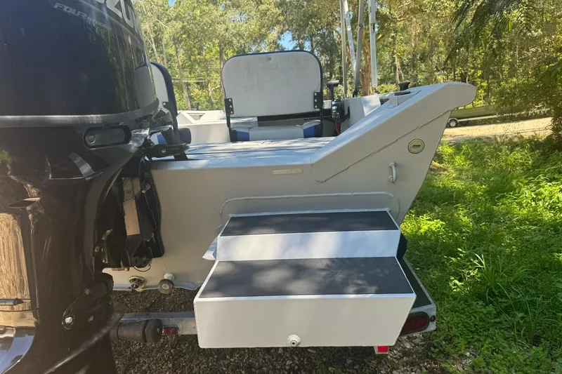 Slide: The Image of 2024 SeaArk Shadow 20 boat with outboard motor, rear view in a natural setting. - 6