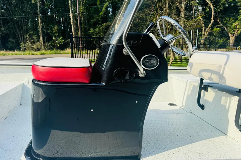Slide: The Image of 2024 SeaArk Shadow 19 v boat console with red seat and steering wheel. - 28