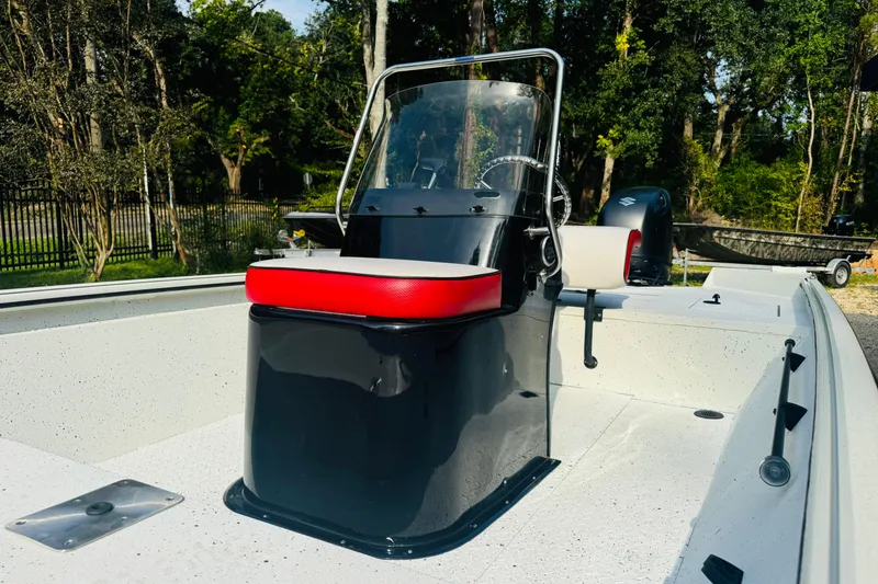 Slide: The Image of 2024 SeaArk Shadow 19 v boat with red seat and black console, surrounded by trees. - 29