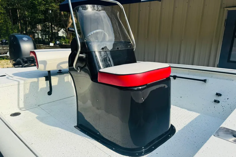 Slide: The Image of 2024 SeaArk Shadow 19 v boat interior with red and black seating, steering console. - 33