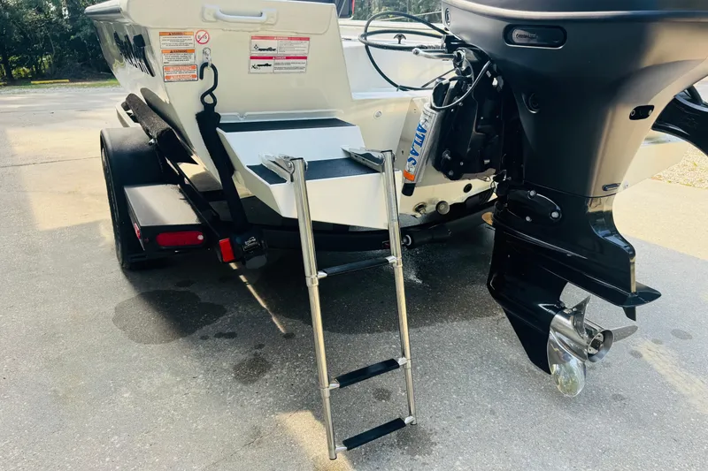 Slide: The Image of 2024 SeaArk Shadow 19 v boat with ladder and outboard motor on trailer. - 8