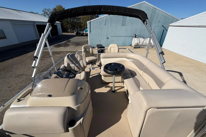 Slide: The Image of 2014 Godfrey Sweetwater 2086 F pontoon boat with beige seating and canopy in a marina. - 12