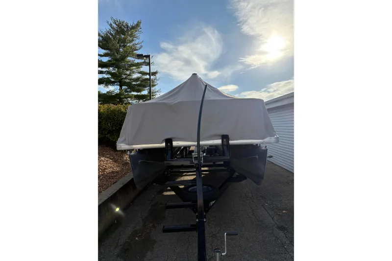 Slide: The Image of 2014 Godfrey Sweetwater 2086 F boat covered, parked outdoors under a sunny sky. - 30