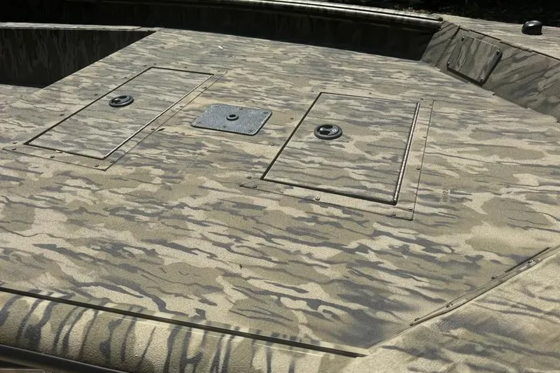 Slide: The Image of 2025 SeaArk 1752 Slayer Pro boat deck with camouflage pattern and storage compartments. - 10