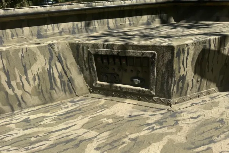 Slide: The Image of 2025 SeaArk 1752 Slayer Pro boat with camouflage interior and control panel. - 14