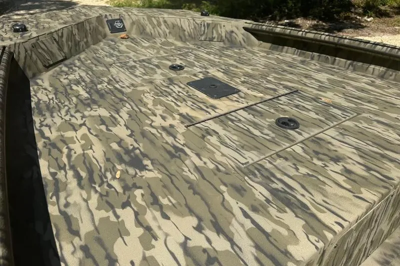 Slide: The Image of 2025 SeaArk 1752 Slayer Pro boat with camouflage pattern, featuring a spacious deck. - 17