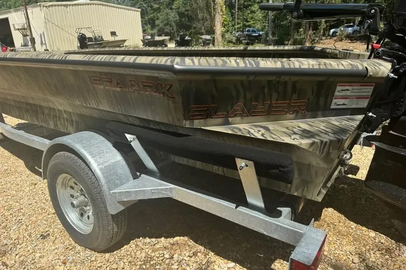 Slide: The Image of 2025 SeaArk 1752 Slayer Pro boat on trailer, camo design, parked outdoors. - 5